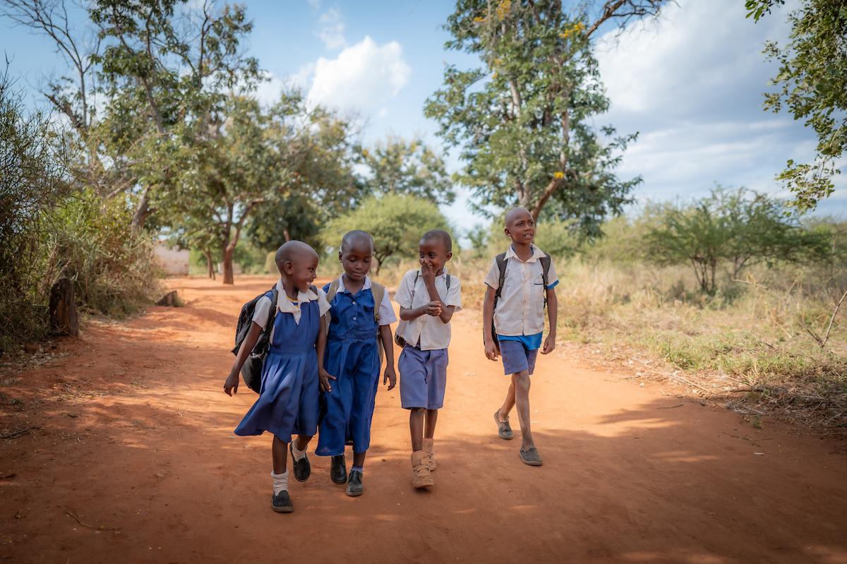 Four school children walking together