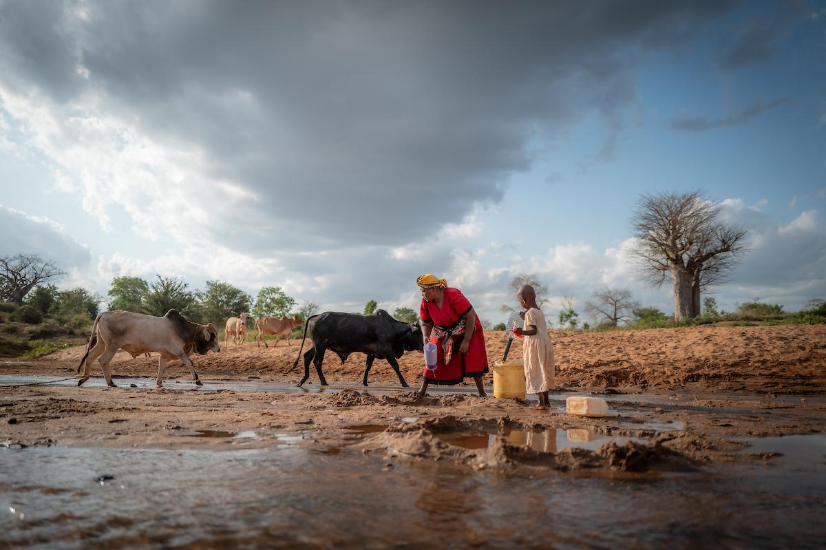 Celestine and her grandmother carrying water