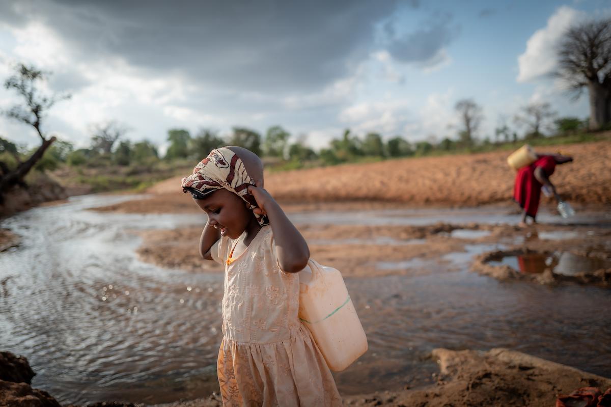 Celestine and her grandmother carrying water