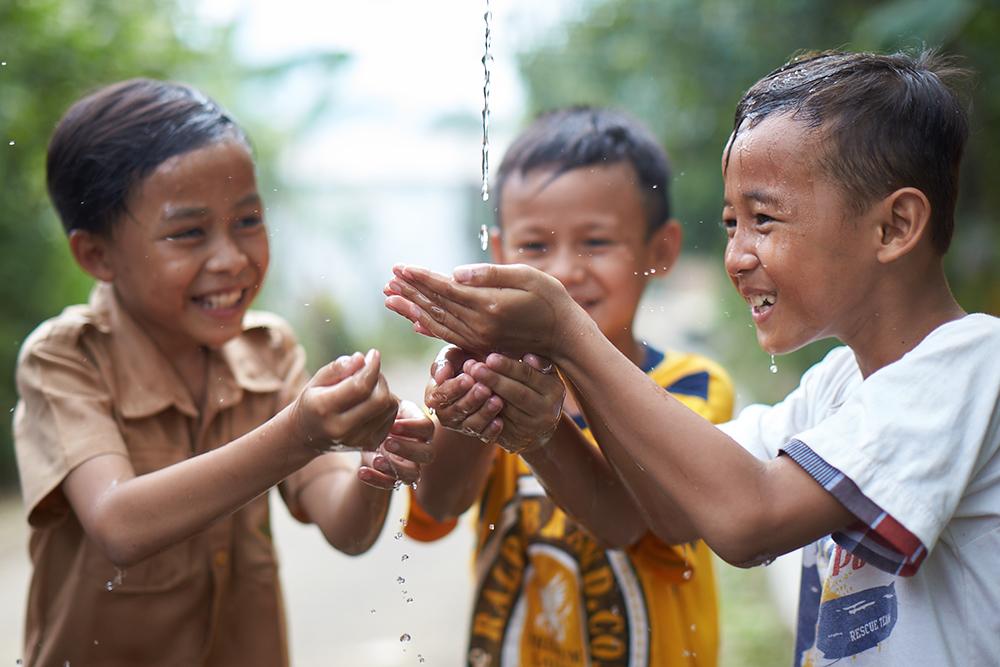 Children catching water in their hands