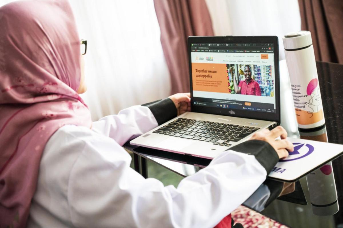 A person working on a laptop at a desk, open to the cherie blair foundation website