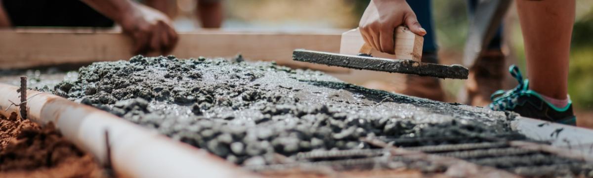 Close up of concrete being spread through rebar