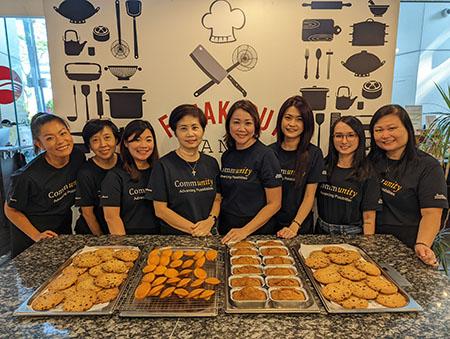 A group of Boston Scientific employees in Singapore standing behind trays of cookies