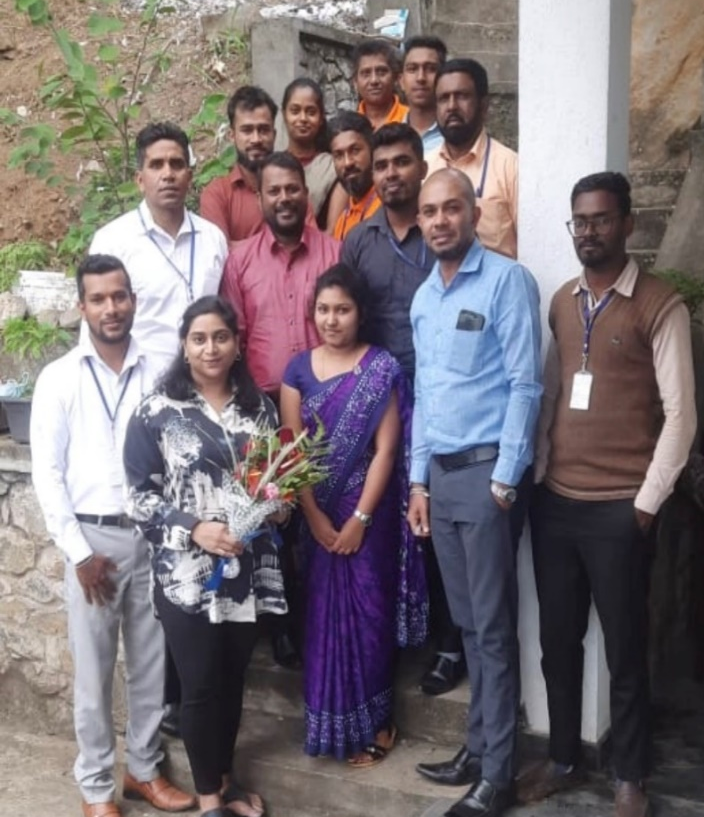 A group of people, one with a bouquet of flowers.