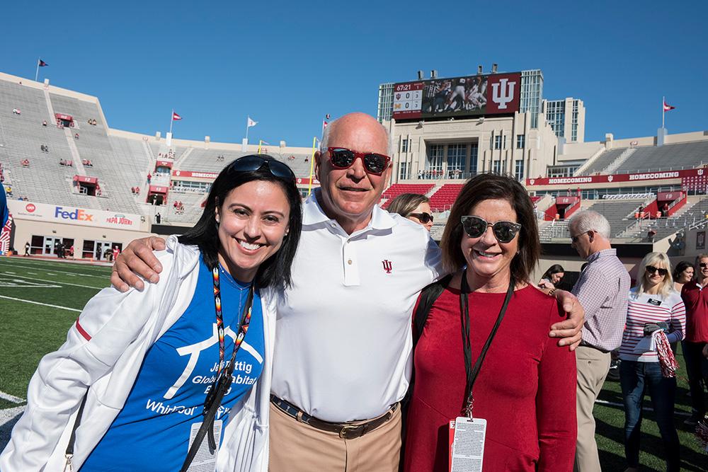 Whirlpool Corporation Community Relations Manager Rosa Hires (left) and former CEO Jeff Fettig (center) pose at the Indiana University football game with a Habitat Home recipient.