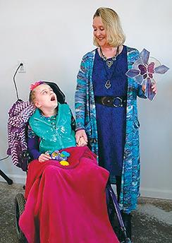Becky Gable-Giblin and her daughter Mariah look at the cross they were presented for their new home last Sunday. (Putnam Sentinel/Nancy Kline)