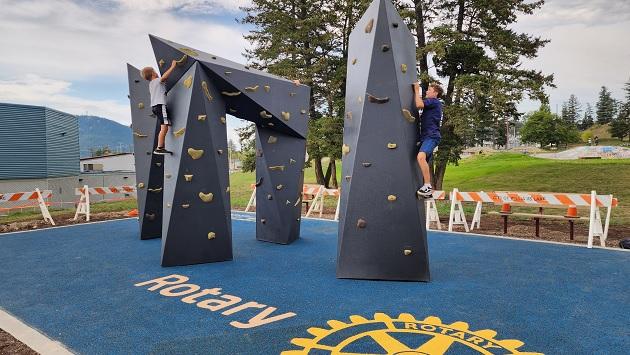 A child climbing a boulder apparatus at an outdoor playground