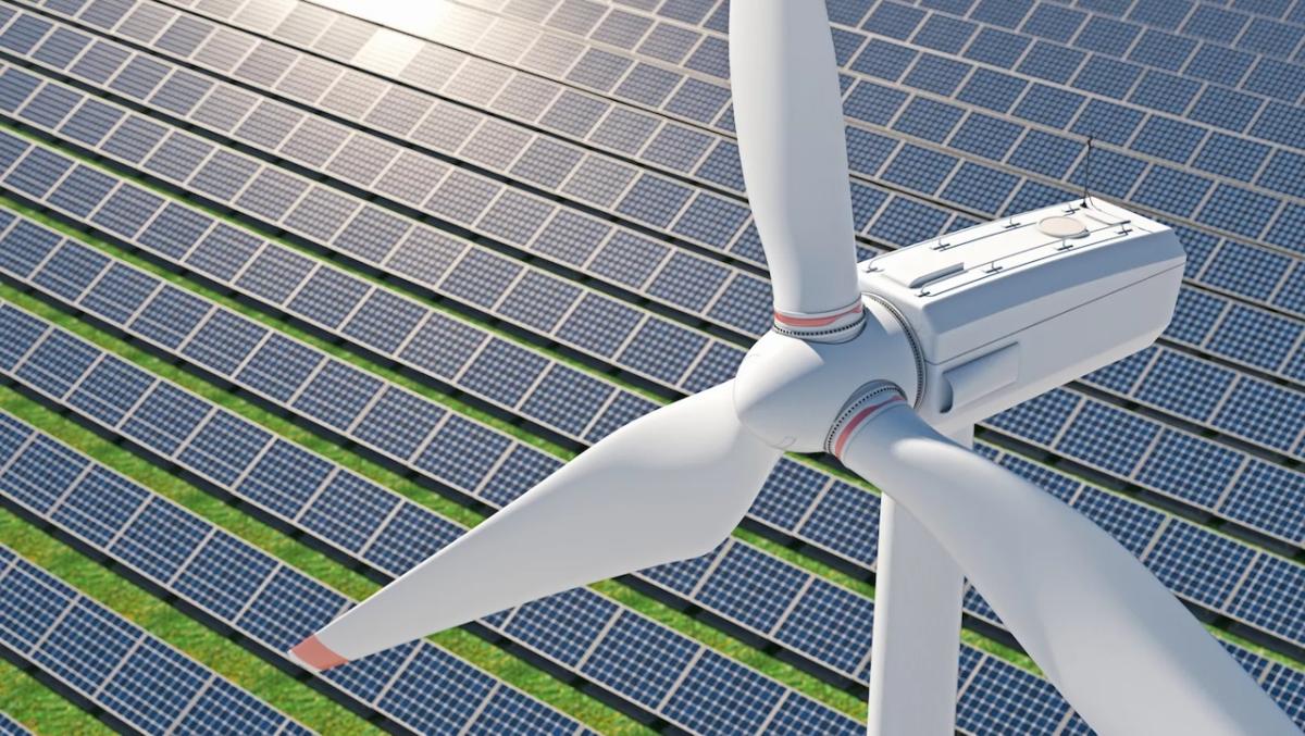 Windmill shown against a backdrop of solar panels.