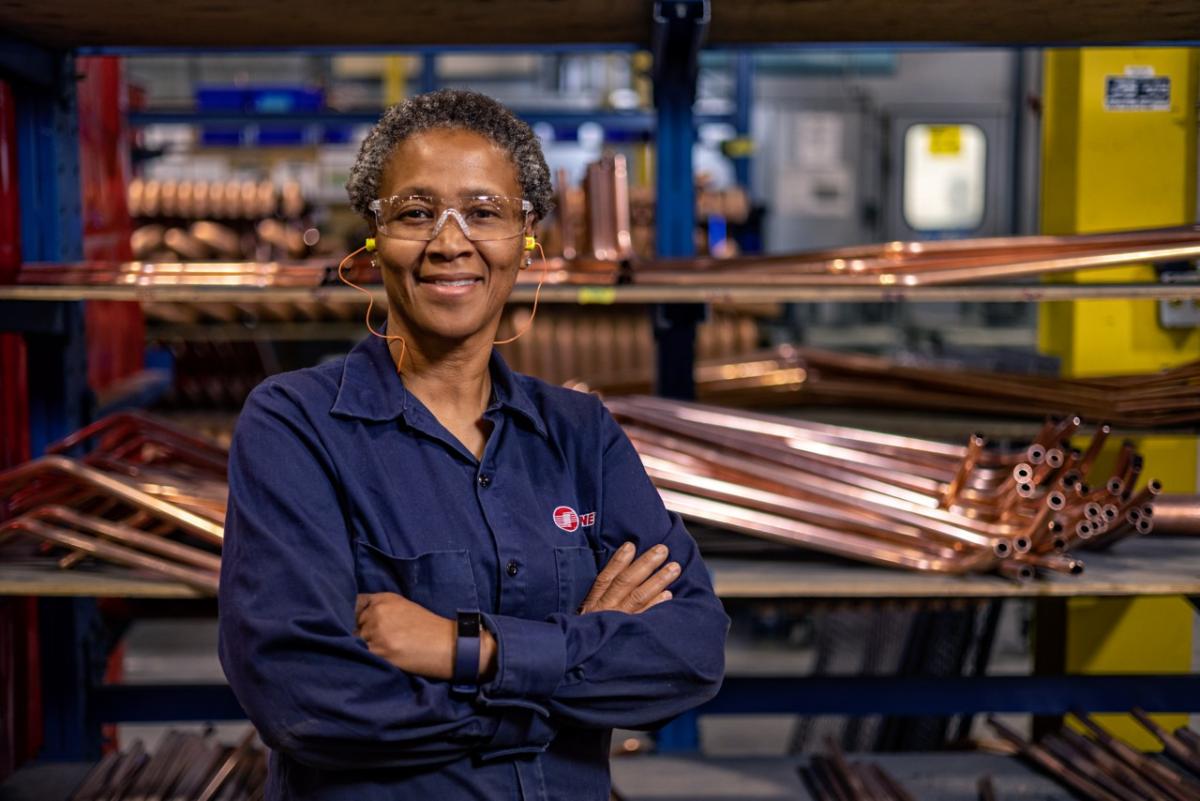 Woman with her arms crossed in a factory