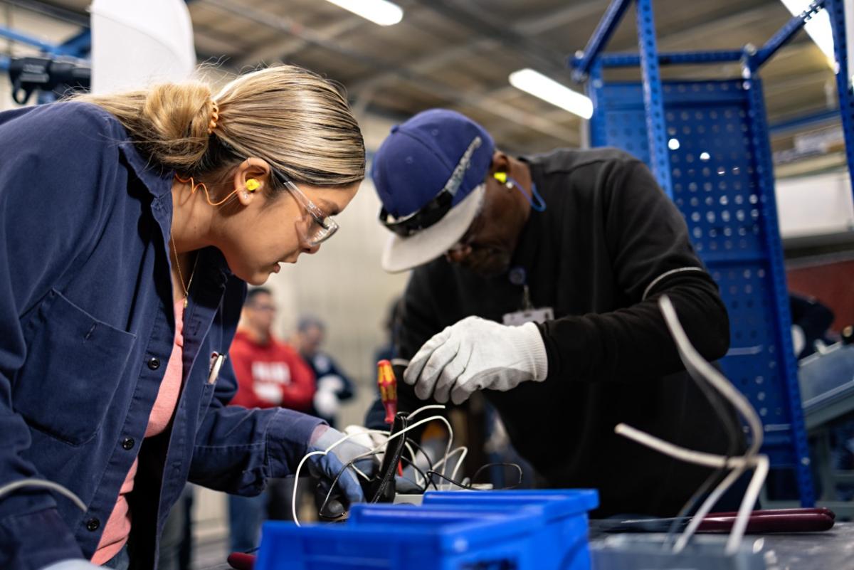 Two people work on electronics