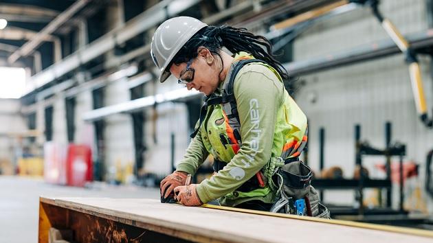 A woman wearing safety equipment in a workshop
