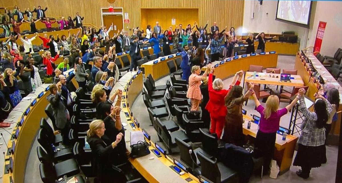 People in an auditorium raising their hands