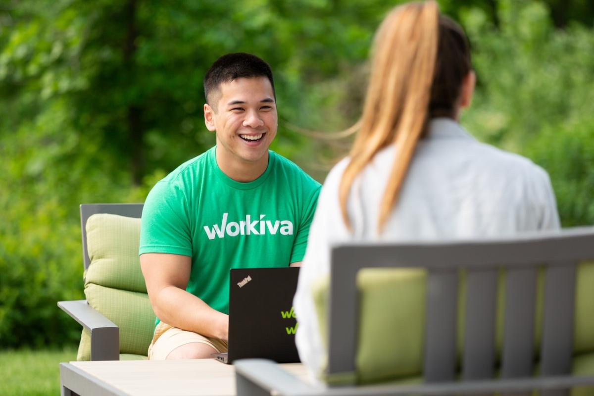 Workiva team members shown working on a back porch with a laptop.
