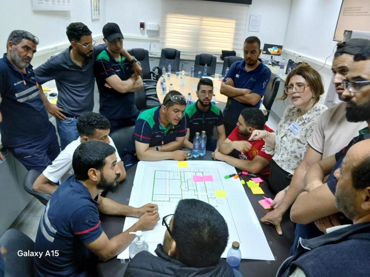 Group standing and looking over paper laid out on table