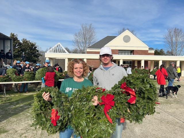 people holding up wreaths