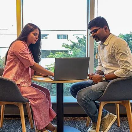 Yash and her supervisor meeting, looking at an open laptop.