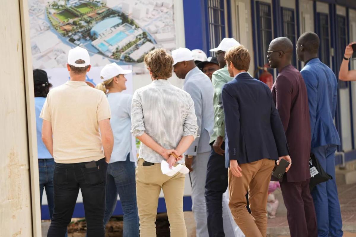 Group standing outside, looking at rendering