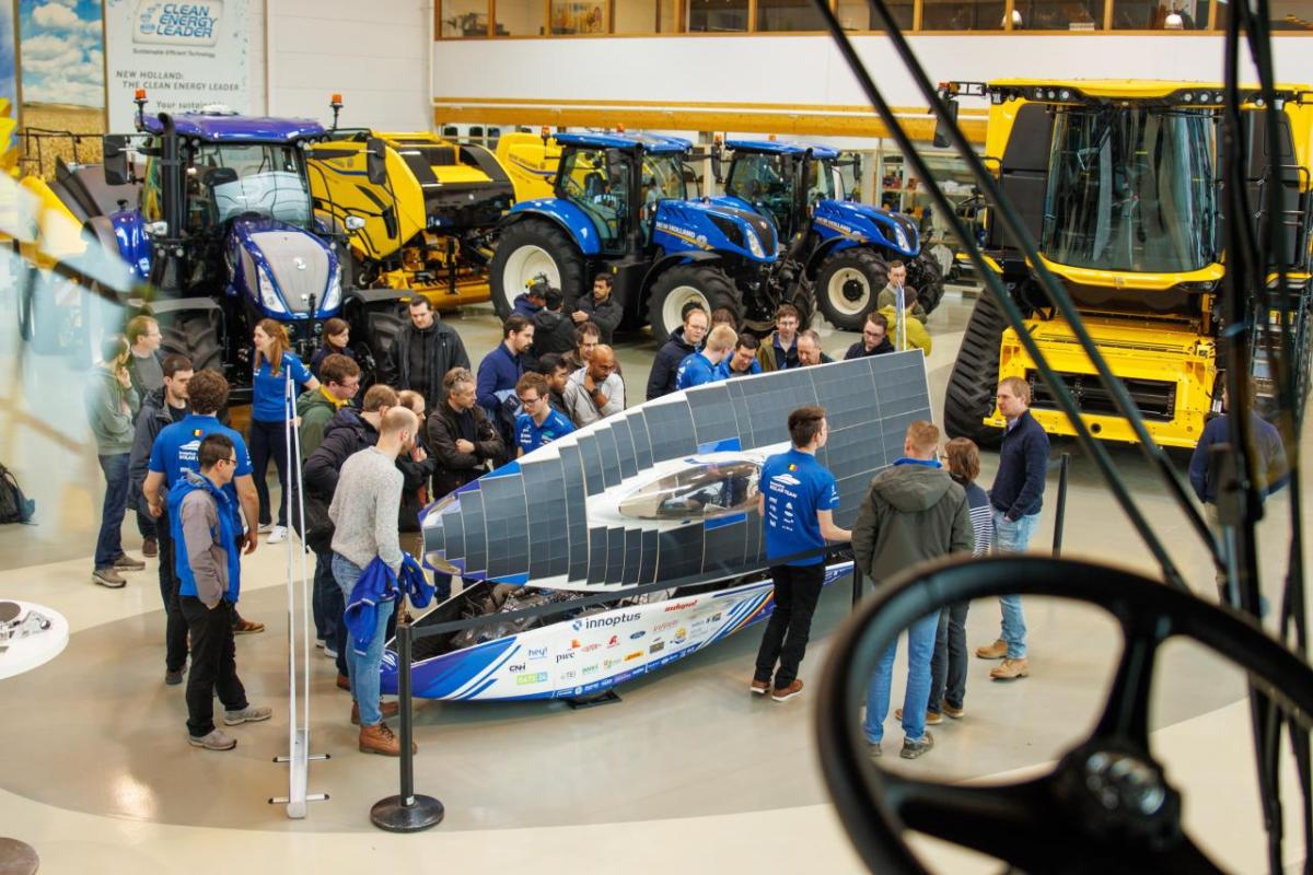 People stood around a solar car at Zedelgem showroom