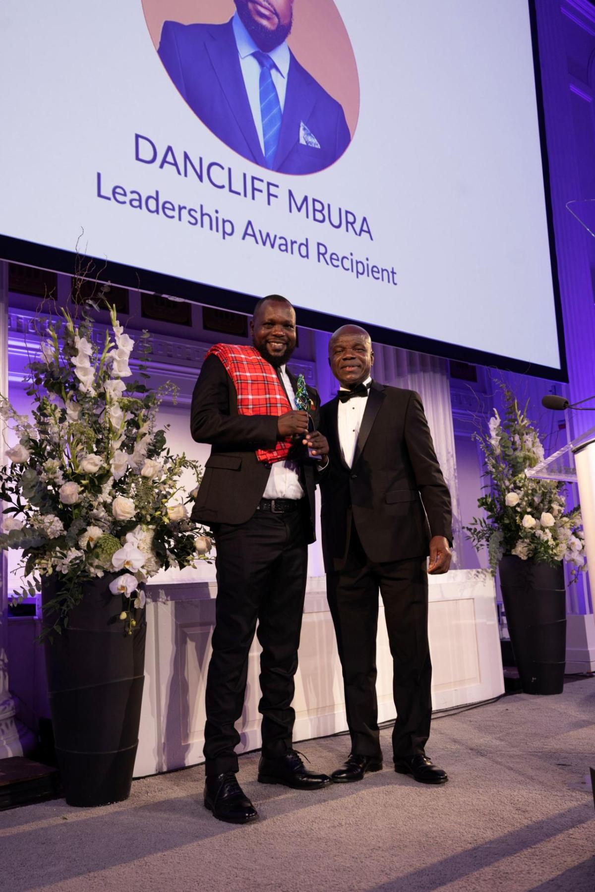 Dancliff Mbura accepts the Leadership Award from Dr. Charles E. Owubah, CEO of Action Against Hunger