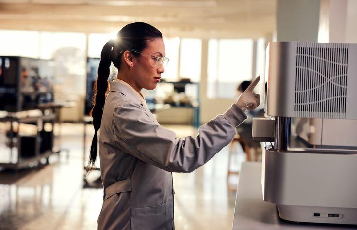 Female clinician operating an Illumina sequencer.