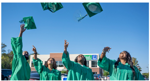 People in graduation gowns throwing caps.