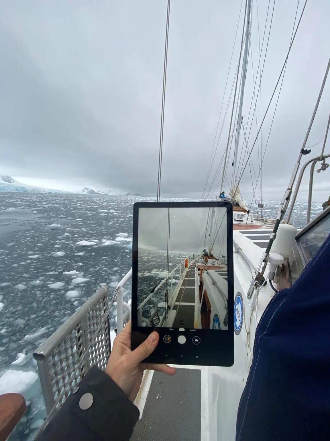 tablet viewing the bow of a small ship in icy water
