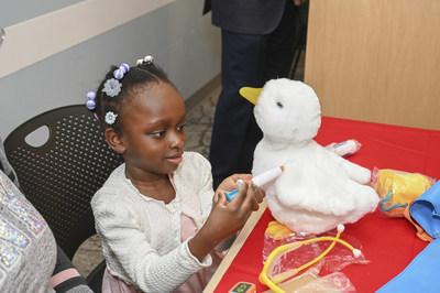 Young black female patient playing with My Special Aflac Duck.