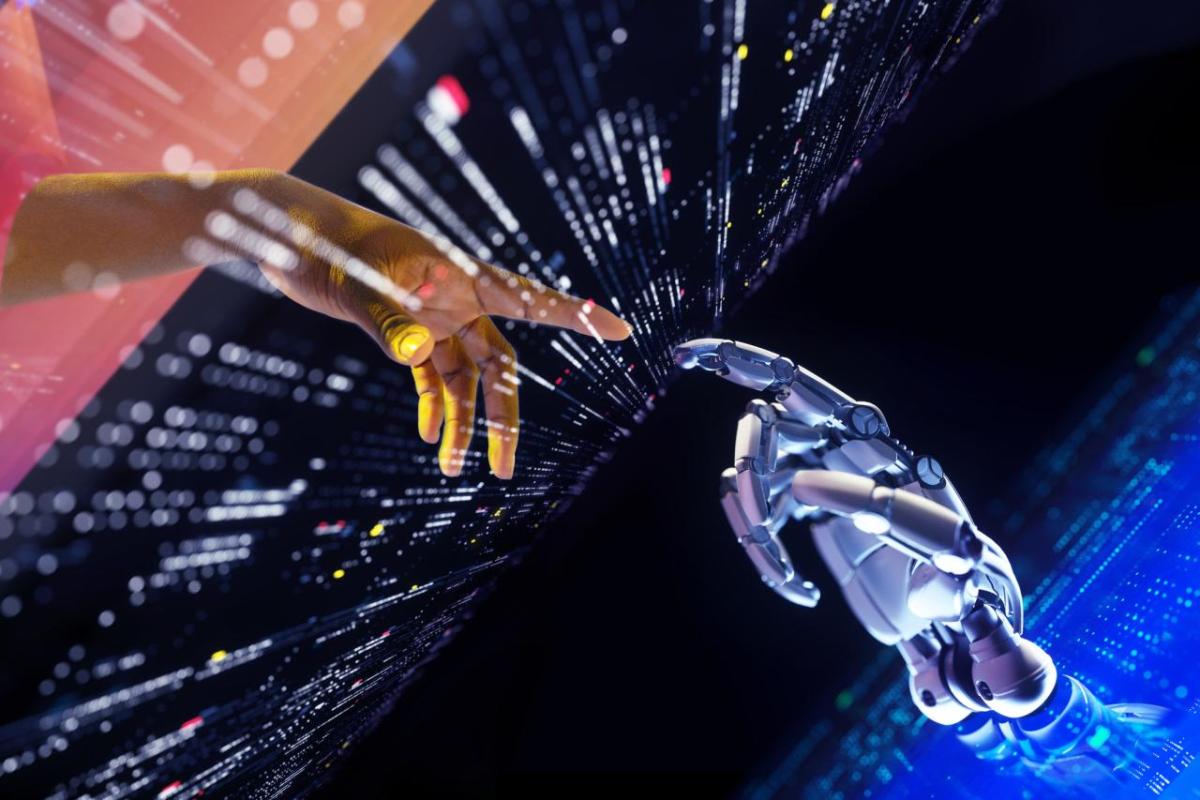 A human and robot hand with pointer fingers extended to each other. A digital screen between them.