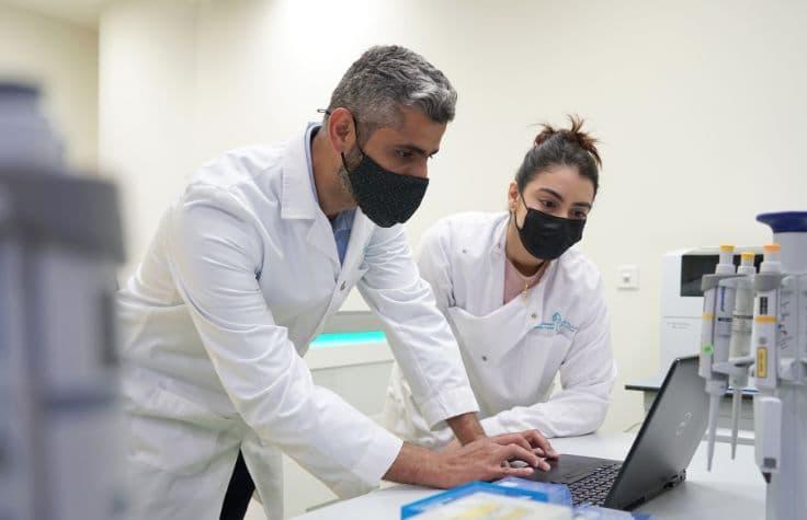  Dr. Ahmad Abou Tayoun and another person using a laptop