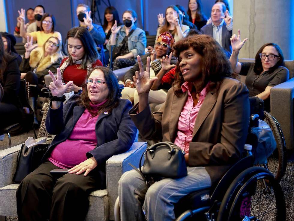 A group of people practicing sign language.