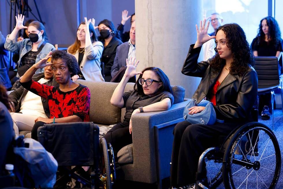 A group of people practicing sign-language.