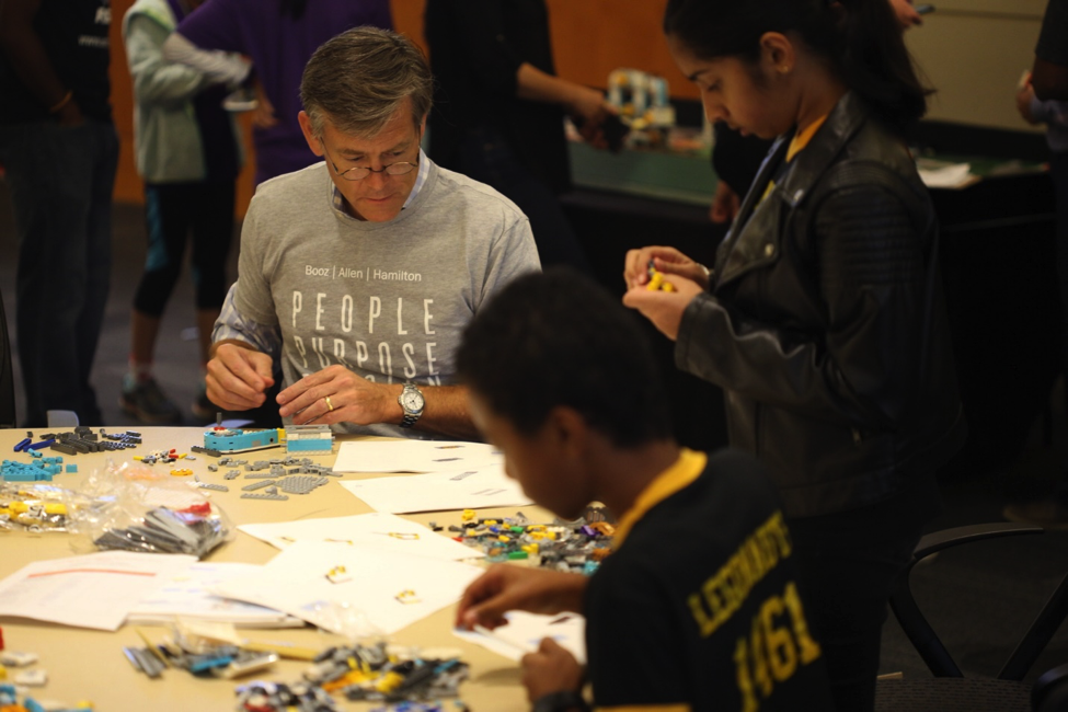 Matt Erskine, executive advisor at Booz Allen, pictured with FIRST LEGO League students.