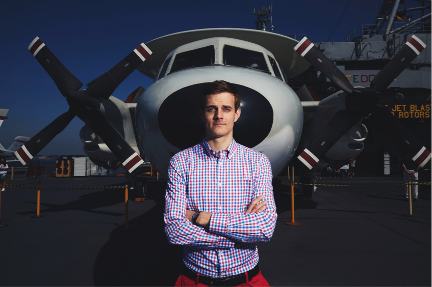 Booz Allen’s Technologist Ethan Wade poses for a portrait on an aircraft carrier in San Diego, CA.