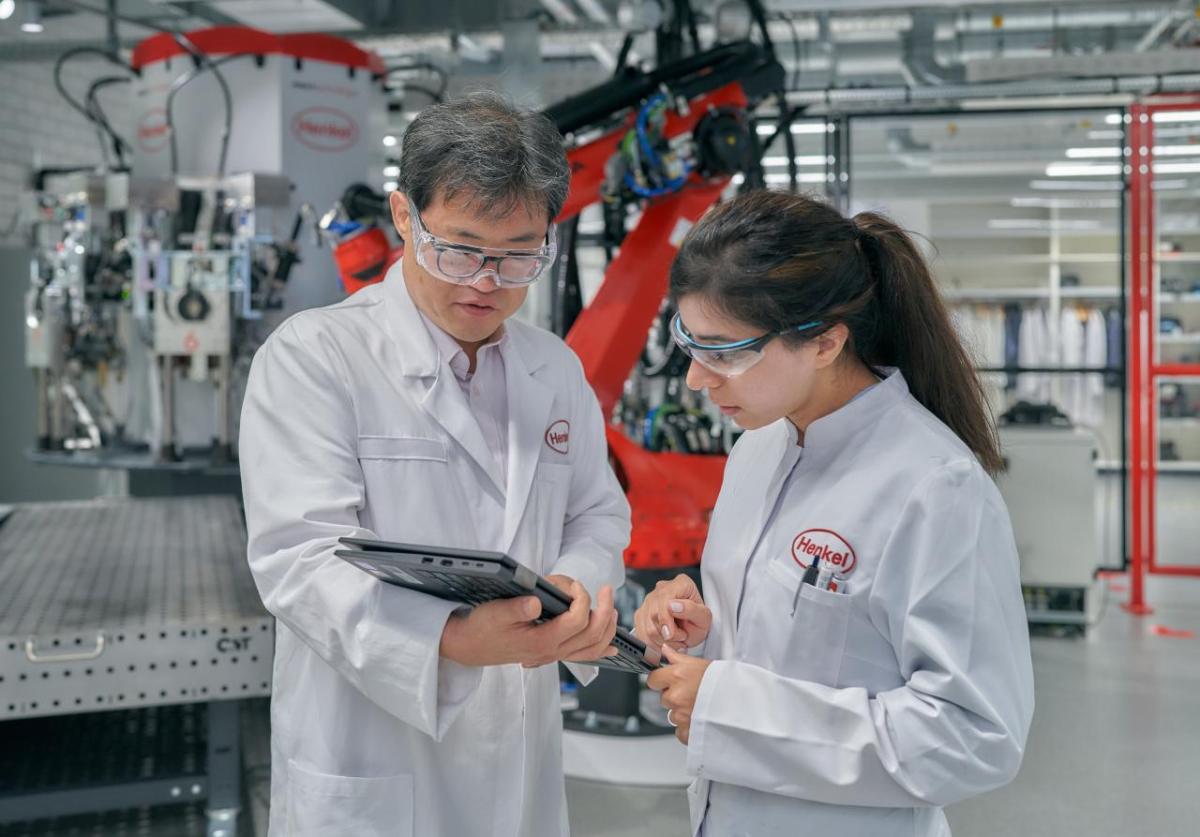 Two people wearing safety goggles and wearing white coats