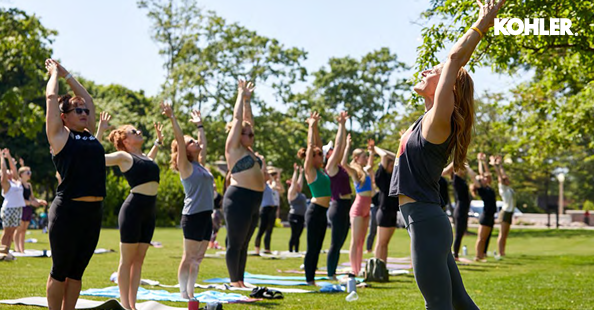 A group of people stretching in a park setting