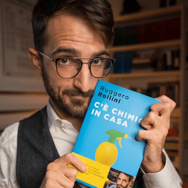 Ruggero Rollini holding up a book he authored