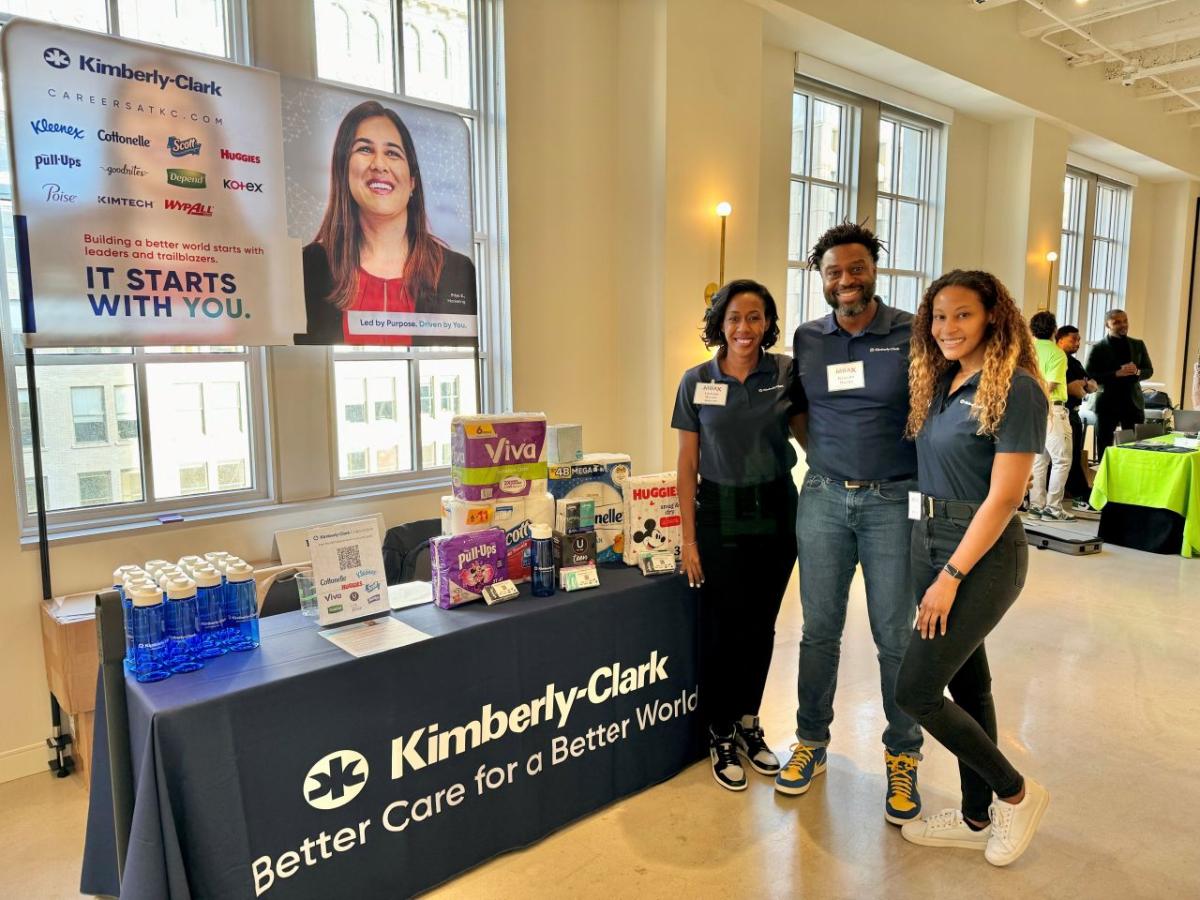 Three people posed at a Kimberly-Clark booth