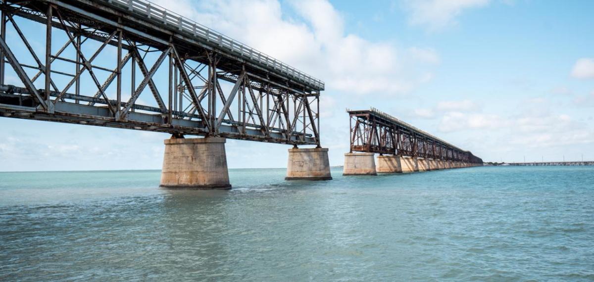 An incomplete bridge over a large body of water.