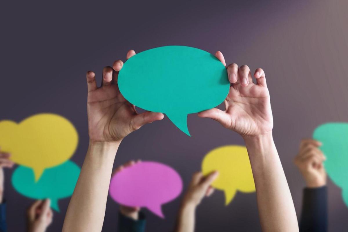 people holding up conversation bubbles 