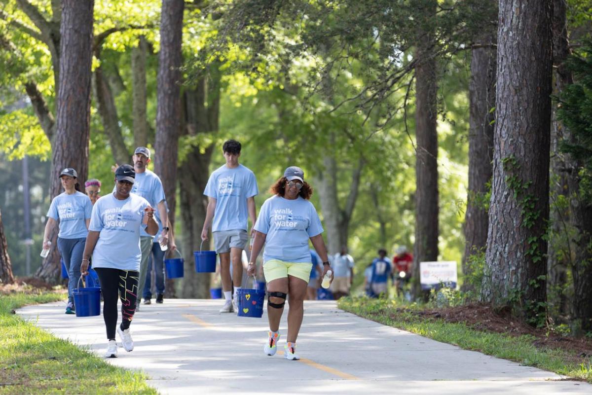 Participants walking with buckets of water 