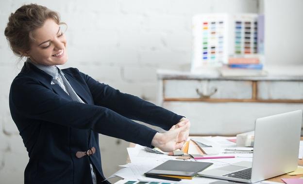 Businesswoman stretching arms at work to relieve muscle tension.