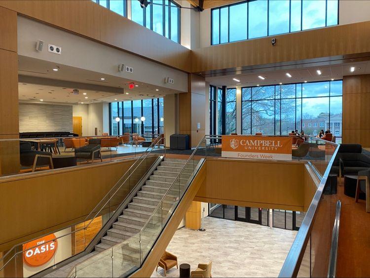 A stairwell of a multi story building "Campbell University" banner on a handrail.