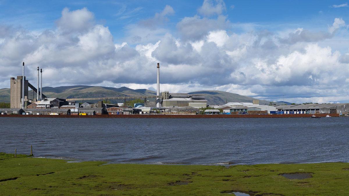 Panoramic view of a wide water way and multiple buildings and hills in the distance.