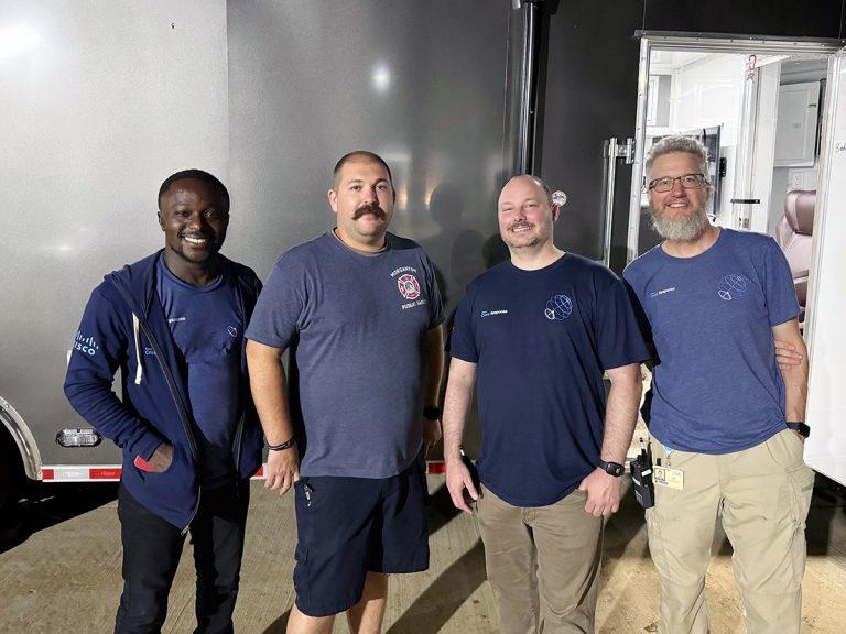 Part of the Hurricane Helene response team. Four people posed in front of a trailer
