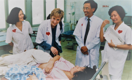 Smiling healthcare workers next to a patient in a bed