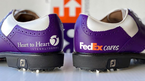Purple and white bowling shoes, one saying "Heart to Heart International" and the other saying "FedEx Cares"