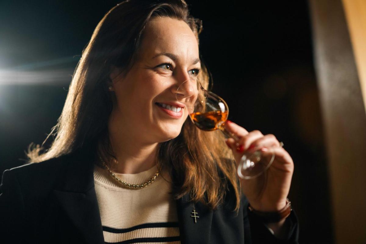 Agathe Boinot smiling, smelling a small glass of cognac.