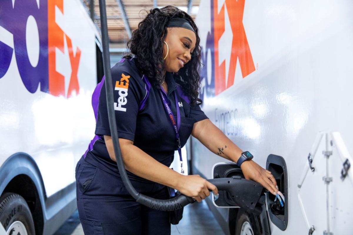 FedEx employee charging an electric vehicle 