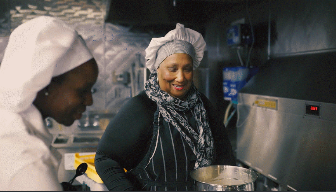 Chef Cherie Beasley of Kitchen Food Ventures, a community-based nonprofit, demonstrates a crab and shrimp bisque soup and cornbread muffins using induction cooktops and energy-efficient ovens. Chef Cherie Beasley with chef hat in kitchen