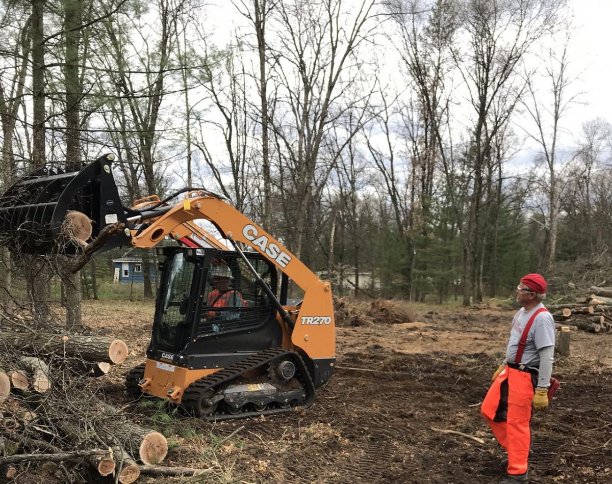 Members of Team Rubicon work on the new Veterans’ Village in Baldwin, Michigan, USA using a CASE skid steer loader